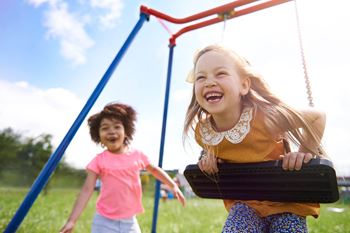 Two children playing in swing set, Clarendon Court Apartments Arlington, VA